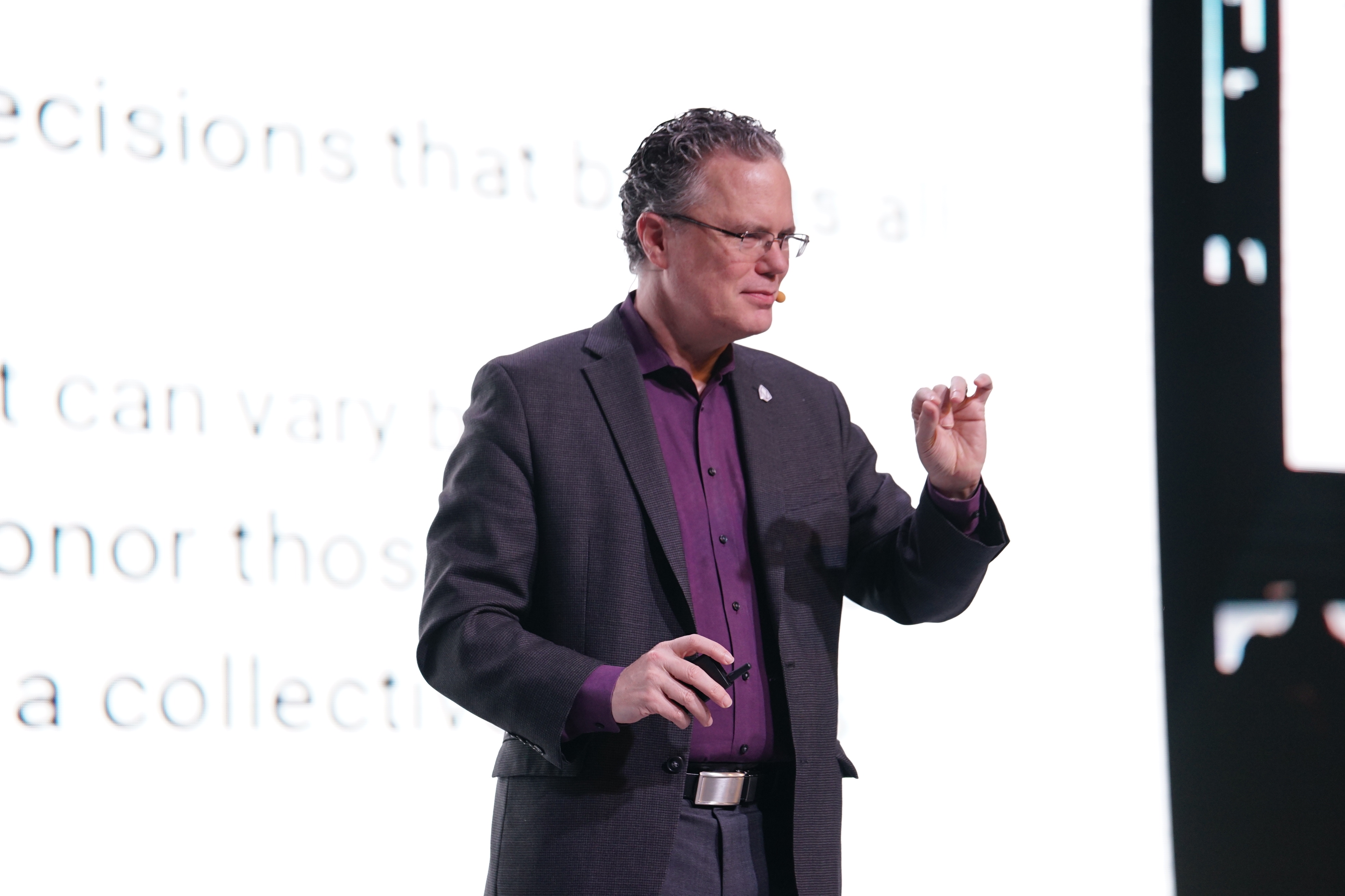 A medium shot of Thomas Cox speaking from a stage in Seoul, South Korea.