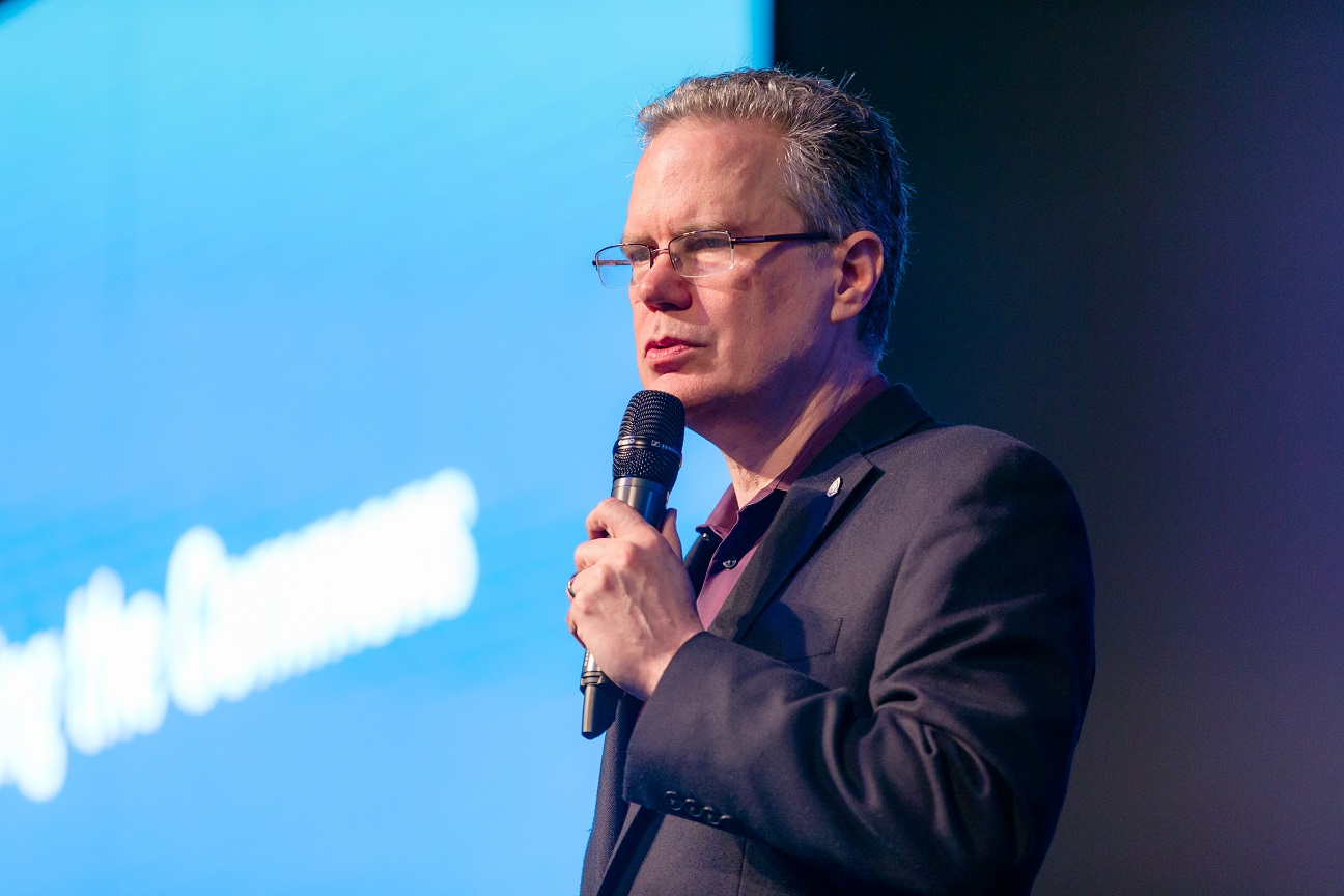 Close up of Thomas Cox speaking on stage in Seoul, South Korea.